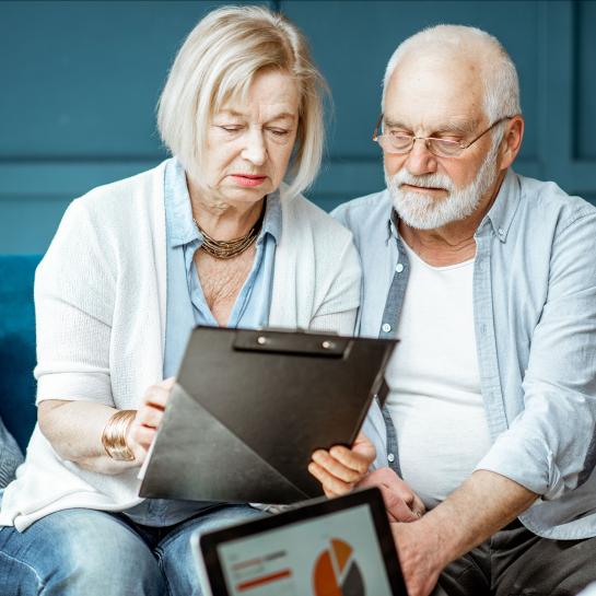 Senior husband and wife looking at chart