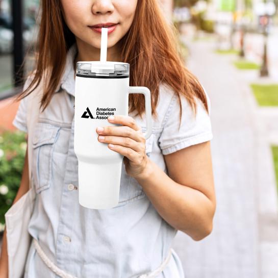 Asian woman holding large, white ADA drink tumbler
