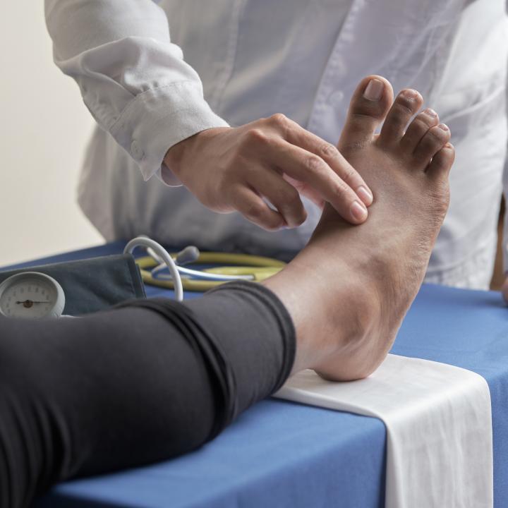 doctor checking pulse of a womans foot