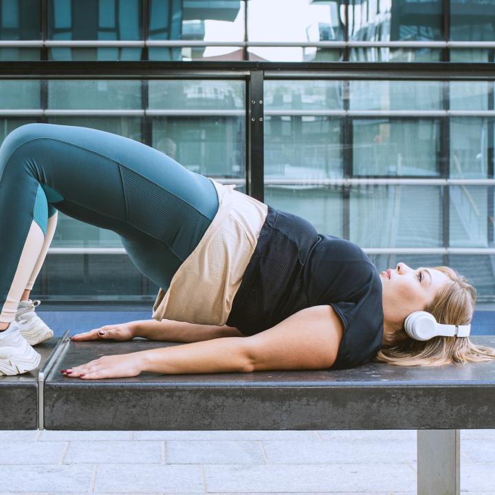 Woman stretching outside wearing headphones