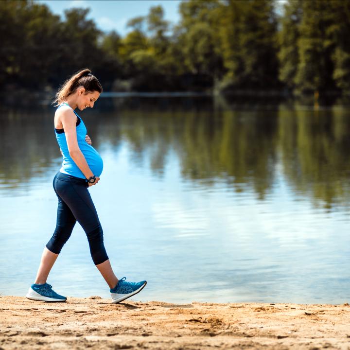 Pregnant woman walking along lake