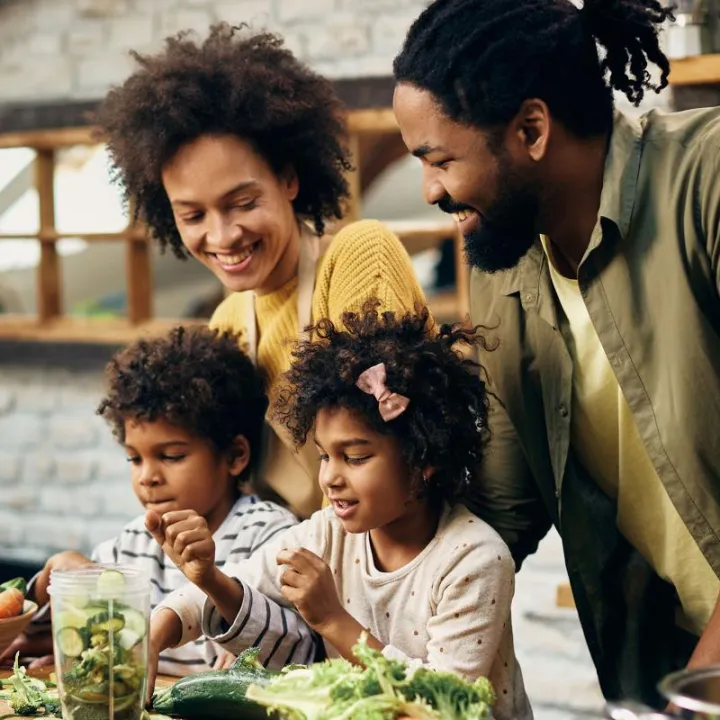 Happy African American family preparing dinner in kitchen