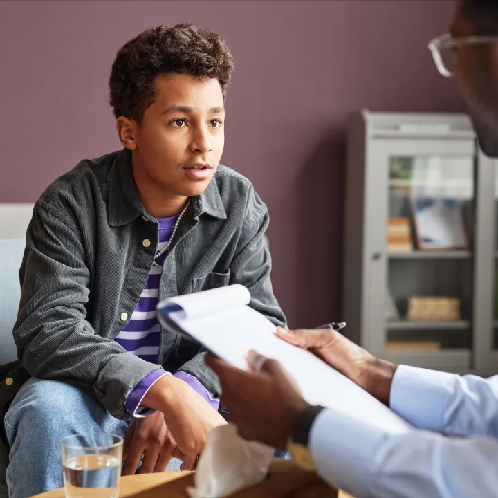 Teenage boy talking to doctor in office