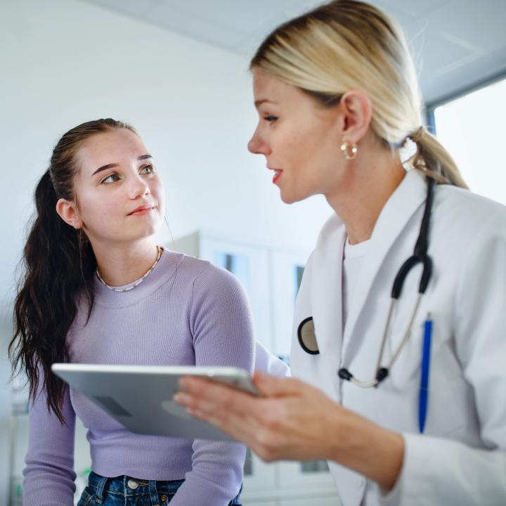 Teen young woman speaking to female physician