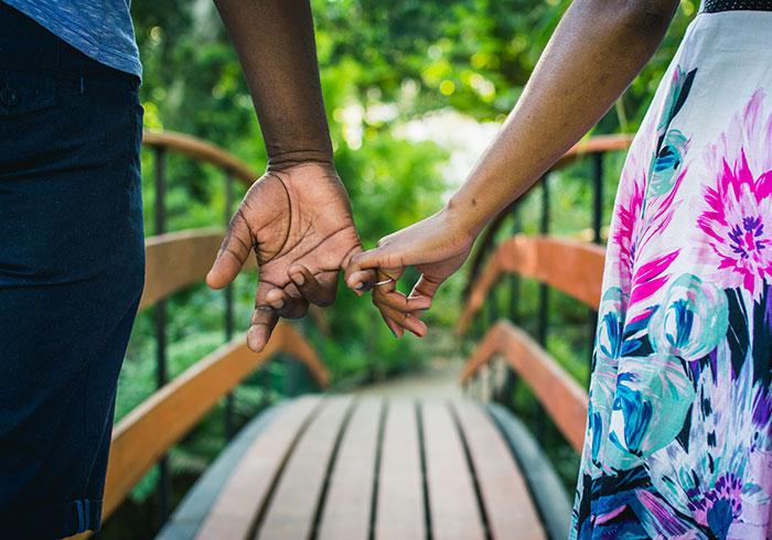 african-american-couple-holding-hands-walking-on-bridge