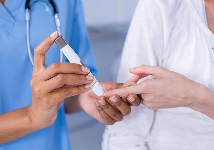 doctor-checking-blood-sugar-level-patient-fingerstick