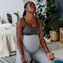 Young pregnant African American woman doing yoga