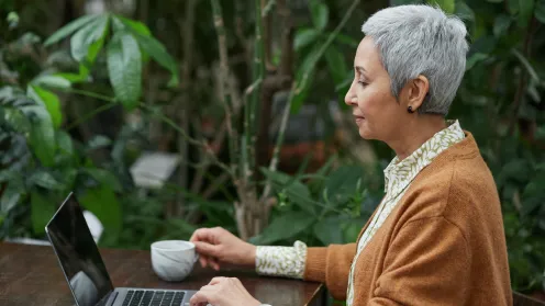 woman sitting in garden at the computer