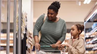 African American mom and daughter shopping in grocery store