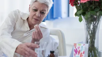Senior woman in bed taking medication