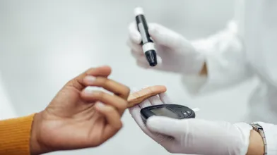 Close-up of person getting blood glucose tested with lancet