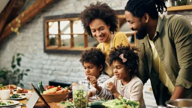 Happy African American family preparing dinner in kitchen