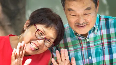 Senior Asian husband and wife having video chat on laptop computer
