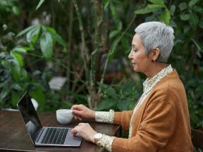 woman sitting in garden at the computer