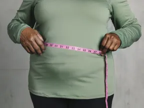 Heavy African American woman holding measuring tape around her waist