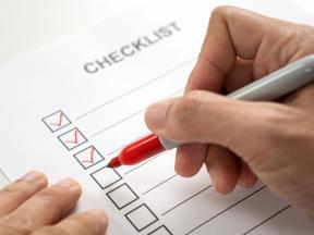 Person filling in checklist with red sharpie