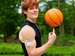 Young man spinning a basketball on his finger with an insulin pump on his arm