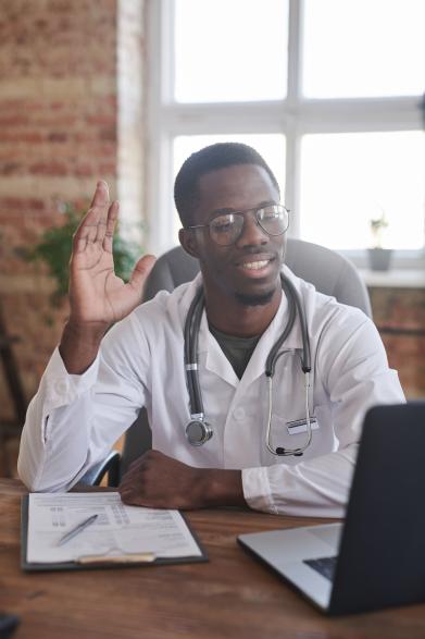 Doctor greeting patient over video call on computer