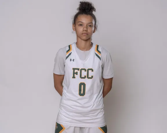 Female athlete in white "FCC 0" basketball uniform.