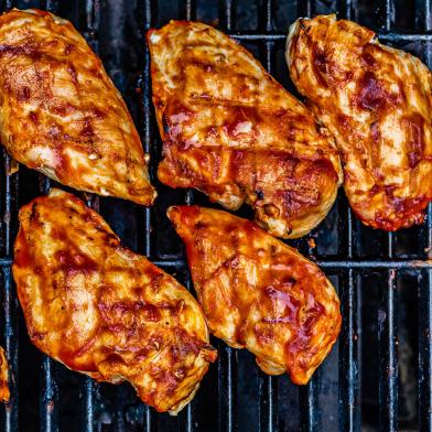 Grilled BBQ chicken breasts on grill