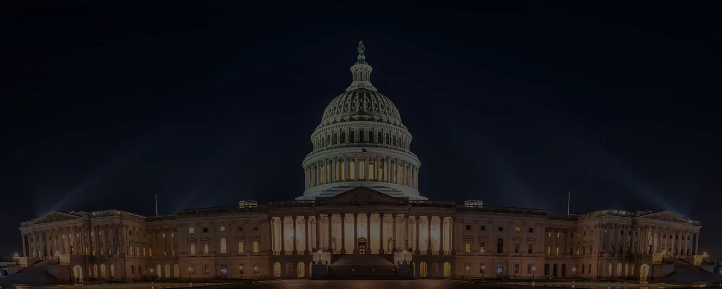 US Capitol Building at night, lit by spotlights.
