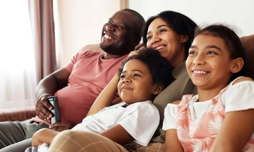 Family on couch watching television