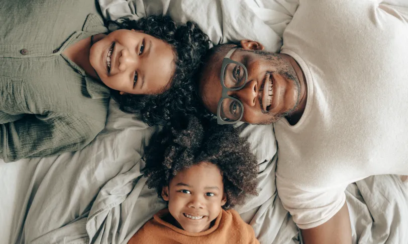 A dad wearing glasses plays with his 2 kids as a reminder as to why he wants to protect his vision from diabetes