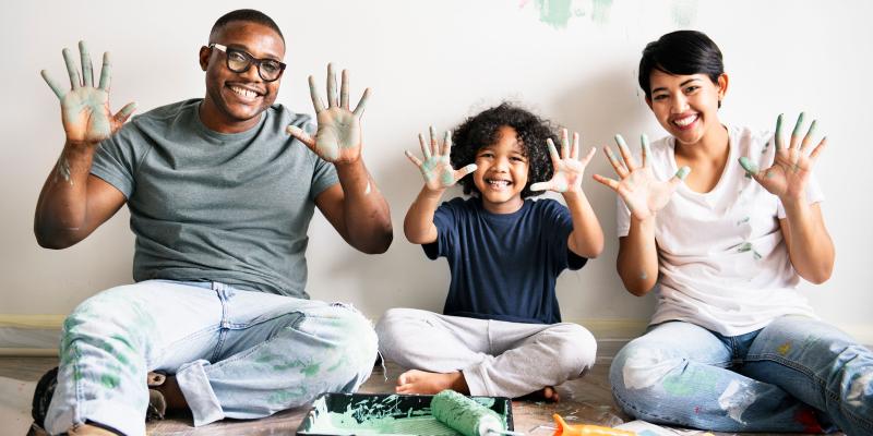 Happy family painting room with paint on their hands