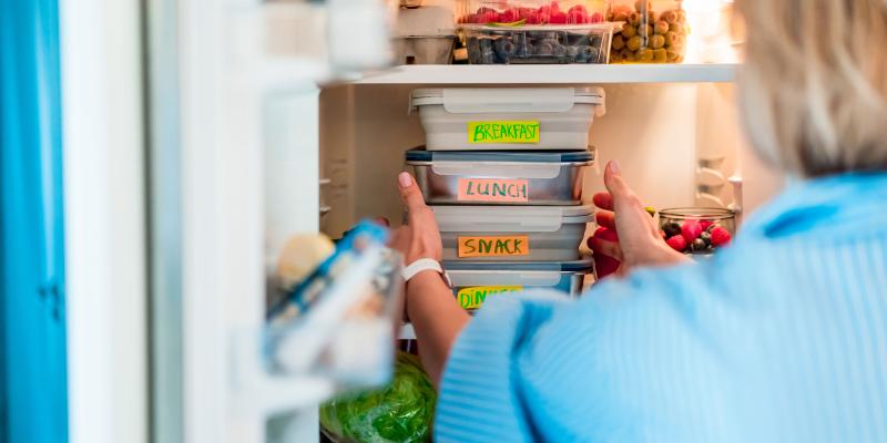 Woman putting planned meals into refrigerator