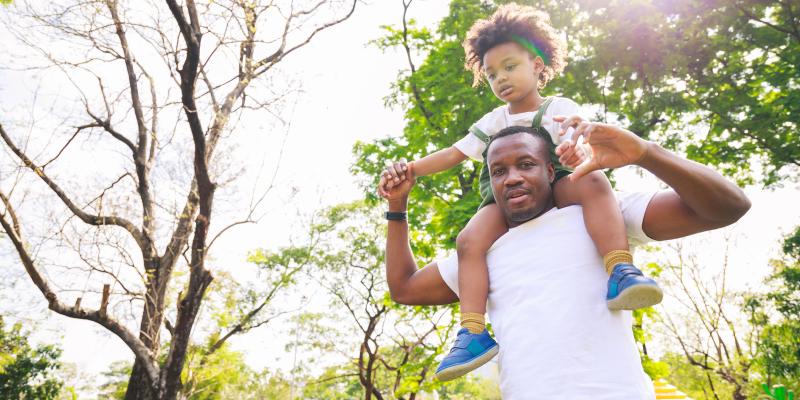 African American father with son on shoulders