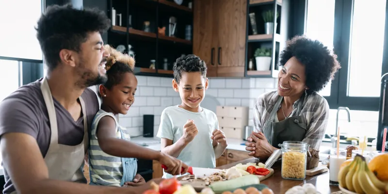 Happy family at kitchen table eating healthy meal.