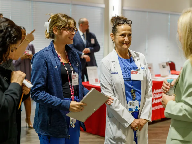 Healthcare professionals smiling and talking at an ADA event.