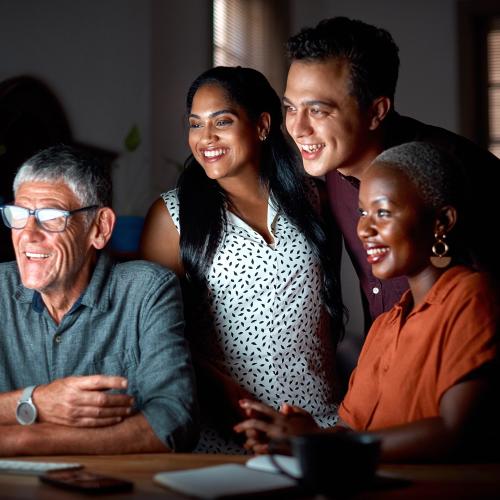 Smiling multi-ethnic group of people looking at computer screen