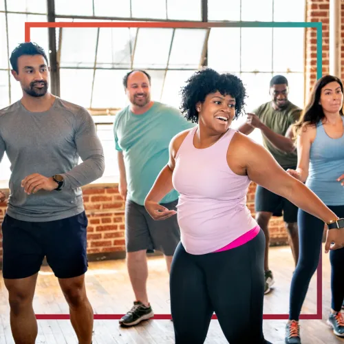 Racially mixed group of young adults in exercise class