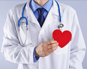 a doctor holding a red papercut heart shape