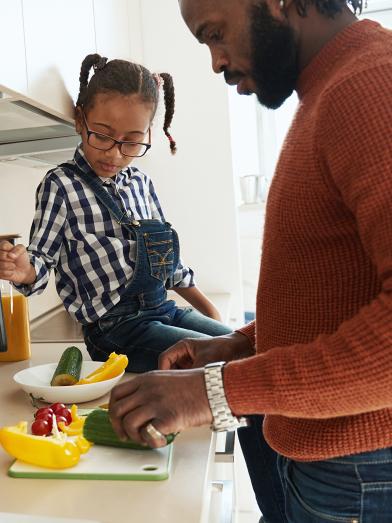 African American father and daughter preparing food