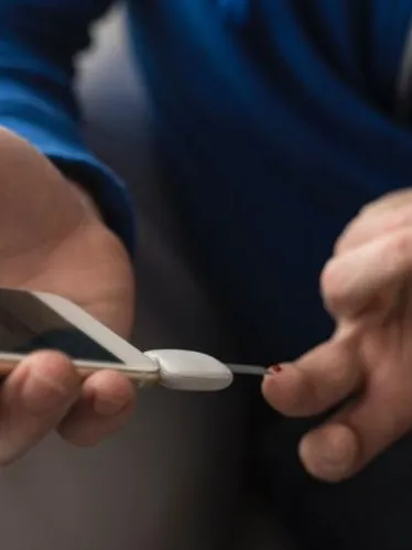 Person checking blood glucose with meter