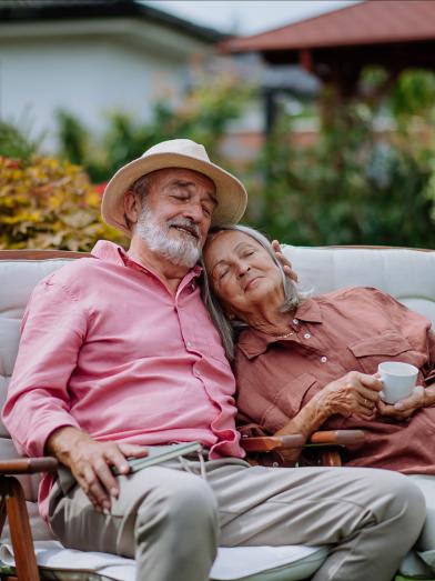 Contented senior couple relaxing on couch outdoors