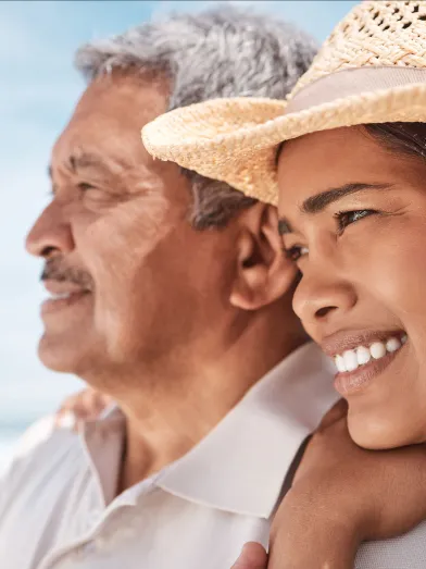 Senior latino father and daughter at the beach