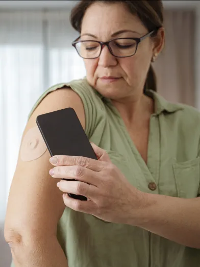 Middle aged woman checking her cgm with phone