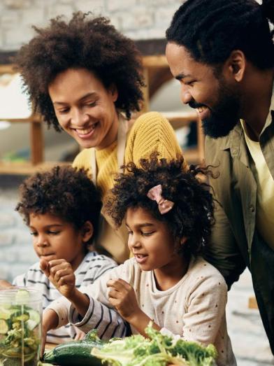 Happy African American family preparing dinner in kitchen