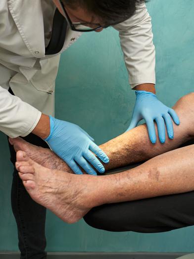 Physician doing an examination of senior mans legs