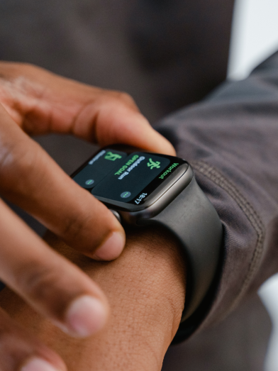 A man's hands touch a fitness watch tracker